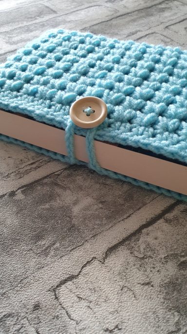 A book sleeve made completely with blue yarn