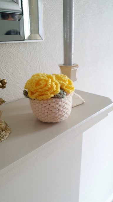 A mini plant pot with yellow flowers in it