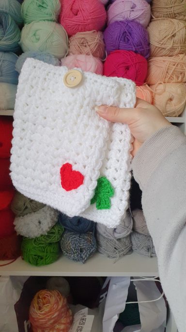 2 kindle sleeves in white, one has a heart on it and the other has a 3 leaf clover